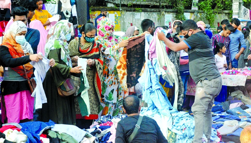 Customers crowd crowd a wayside shop at Motijheel area in the capital on Friday for buying cheap winter cloths.