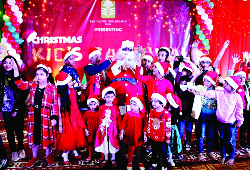 Santa Clause distributes chocolates among children at Hotel Sonargaon on Saturday on the occasion of Christmas Day.