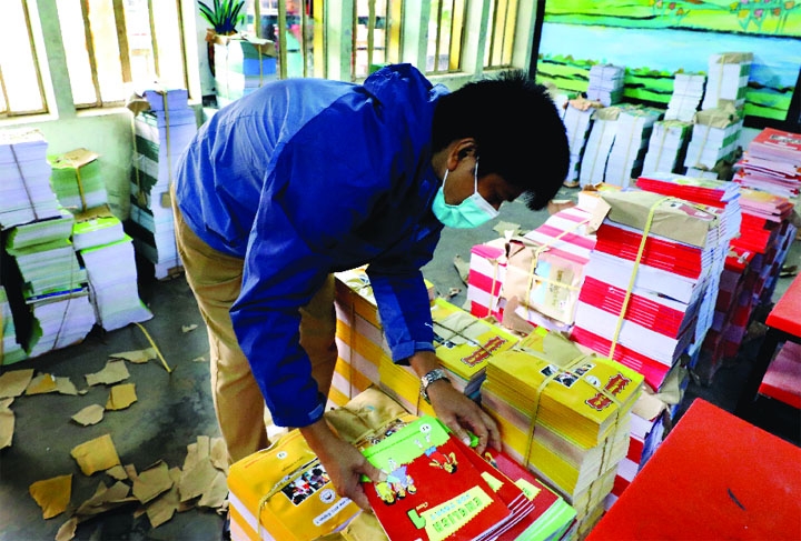 A man sorts books at Ganderia Mohila Somity Govt Primary School in the capital on Sunday as new books are being delivered to educational institutions for distribution to students in the new year.