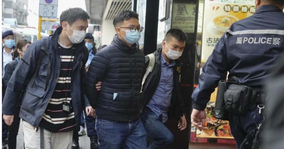 Editor of "Stand News" Patrick Lam, second from left, is arrested by police officers in Hong Kong, Wednesday, Dec. 29, 2021.