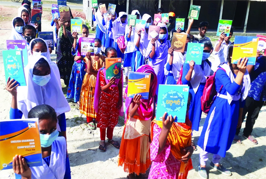 MIRZAPUR(Tangail): Students of Uttar Pakuya Jogorani High School show their new books in the first day of education year on Saturday.