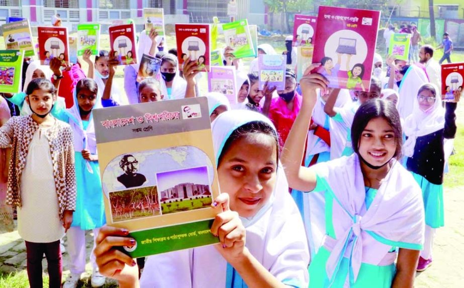 Students of Bawany Adarsha Viddalaya at Demra in the capital show their new textbooks for the coming school year on Saturday. NN photo