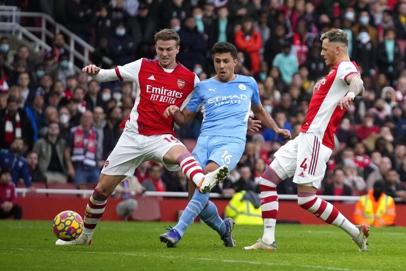 Manchester City's Rodrigo (center) shoots to score his side's second goal past Arsenal's Rob Holding (left) and Arsenal's Ben White during their Premier League soccer match at the Emirates Stadium in London, England on Saturday. AP photo
