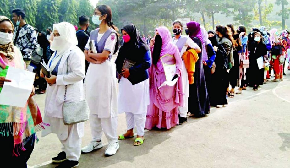 Girl students queue up to receive a Covid-19 shot at the Residential Model College in the capital on Sunday. NN photo