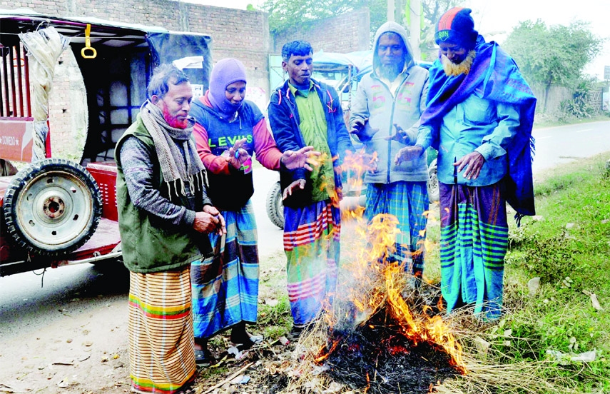 Elderly people create fire even in day hours to keep themselves warm at Savar area on the outskirt of Dhaka for relief from cold weather.