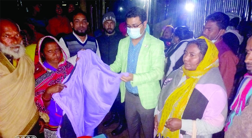 BIJOYNAGAR (Brahmanbaria) : A H Irfan Uddin Ahmed, UNO, Bijoynagar Upazila giving winter clothes at Nomadic slums in Bijoynagar on Monday.
