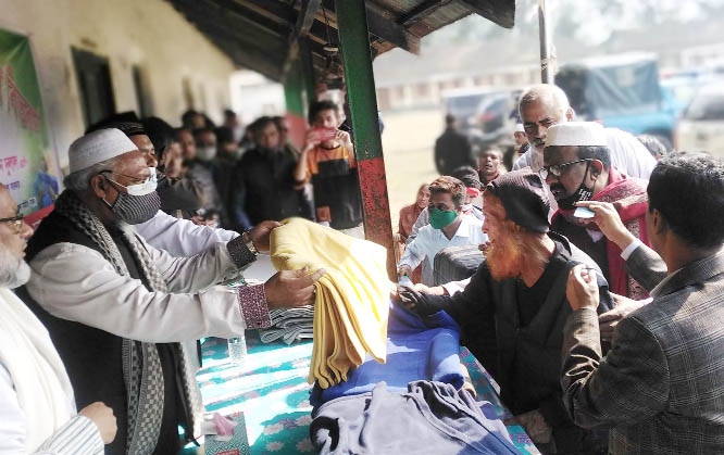 State Minister for Religion Faridul Haque Khan distributes blankets among the cold-hit poor people on Government Islampur Nekjahan Pilot Model High School premises at Islampur in Jamalpur on Friday.