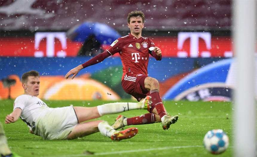 Bayern Munich's Thomas Muller (left) shoots at goal during their Bundesliga match at home to Borussia Moenchengladbach on Friday.