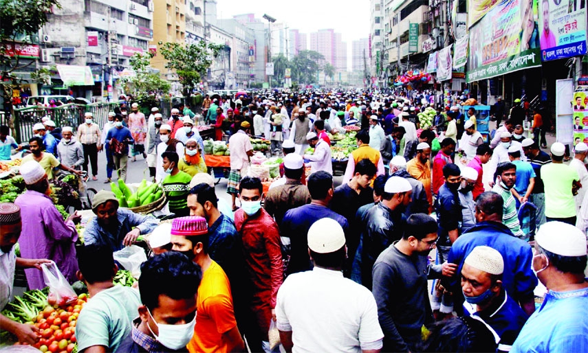 People throng weekly market blocking the main road at Naya Palton area in the capital on Friday violating 11-point restrictions imposed by the govt.