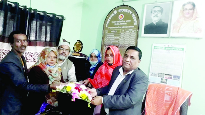 MANIKGANJ: Poet Siraj -ud- Doula greeted by Md Moniruzzaman, Assistant Upazila Higher Education Officer for his sonnet writing at Singair Upazila Education Office in Manikganj recently.