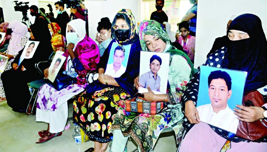Members of disappearance victims’ families hold photos of their loved ones, who disappeared, at a protest rally organised by Mayer Dak held at the Jatiya Press Club on Saturday. NN photo