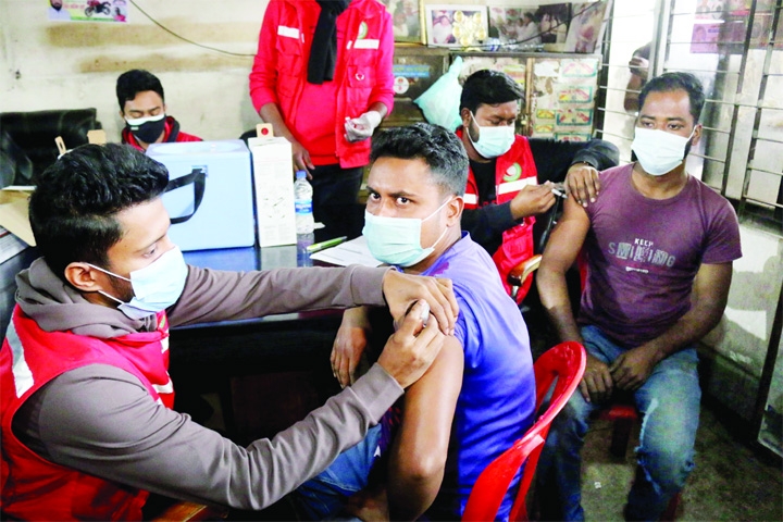 Medical staff inject Covid-19 jabs to public transport workers at Mohakhali Inter district Bus Terminal on Wednesday.