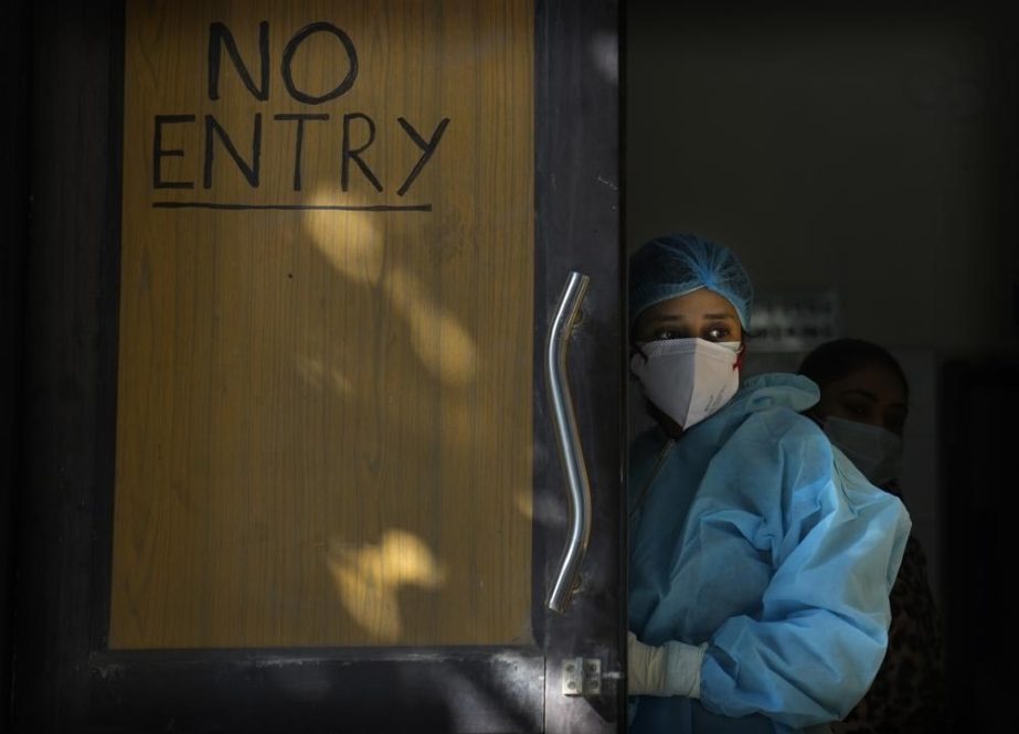 A health worker in personal protective equipment awaits patients for Covid 19 testing at a health center, in New Delhi, India, Friday, Jan. 28, 2022.