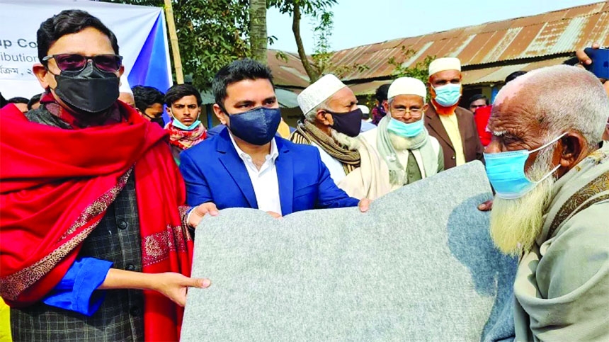 State Minister for ICT Zunaid Ahmed Palak distributes blankets among the destitute on the premises of Joremallika Ningoin Bilateral High School in Singra on Friday.