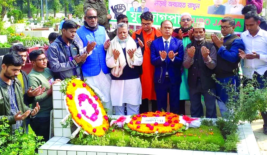 Newly elected committee of Juba JAGPA offers munajat after paying floral tributes at the grave of founder of JAGPA Shafiul Alam Prodhan at Banani Graveyard in the city on Friday.