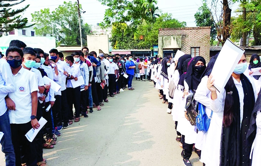 ISHWARDI(Pabna): Students were waiting in a long queue at Ishwardi Health Complex for taking corona vaccine on Thursday.