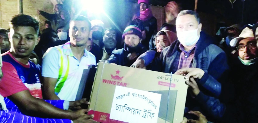 MADHUKHALI (Faridpur): Jahidun Nobi Moni, founder of Byasdi Rashida Nobi High School presents the trophy as the Chief Guest to Noapara Nur Sangho, the Champion team of Badminton Tournament at Byasdi Govt Primary School ground on Friday.