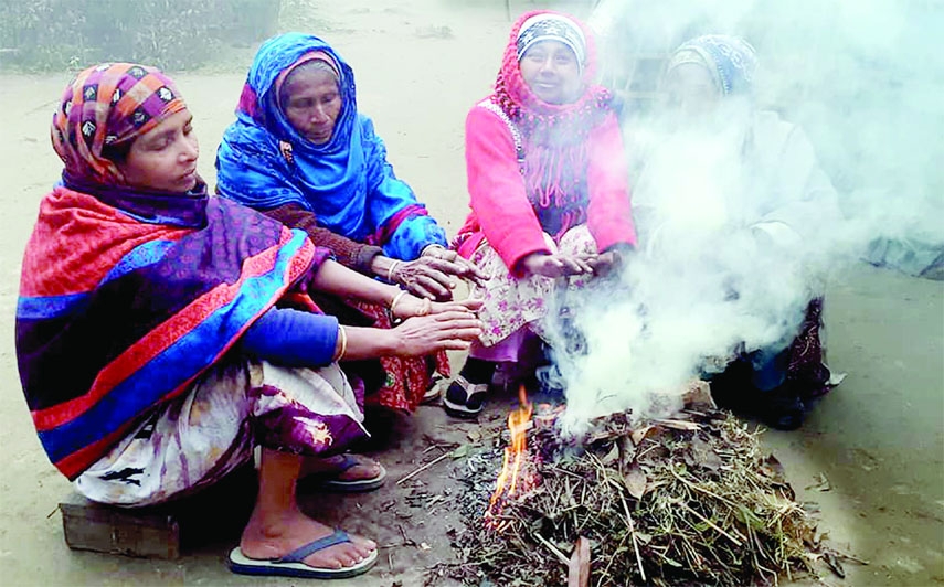 Women set fire to keep themselves warm at Tetulia upazila in Panchagarh district on Monday as the northern parts of the country are shivering in biting cold.