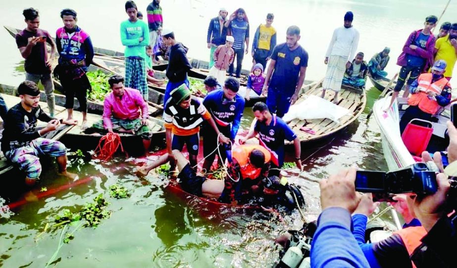 Members of the fire service diving unit conduct rescue operation after a soil-laden trawler sank in the Dakatia River off the coast of Chandpur after hitting a bulkhead early Monday. NN photo