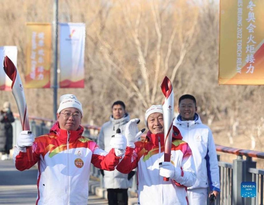 Torch bearers Xu Zhenchao (right) and Wu Ming pose for photos after passing of the flame during the Beijing 2022 Olympic torch relay at the Olympic Forest Park in Beijing, capital of China on Wednesday. Agency photo