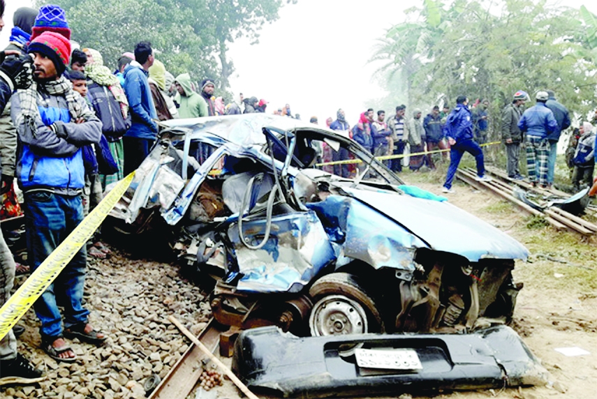 A car gets mangled as a train knocked it at rail gate area under Ghoraghat upazila in Dinajpur district on Wednesday leaving three people dead.