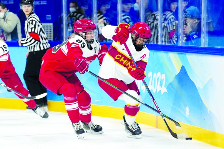 Denmark's Malene Frandsen (left) defends against China's Qiqi Lin (chaina) during a preliminary round women's hockey game at the 2022 Winter Olympics, in Beijing on Friday.