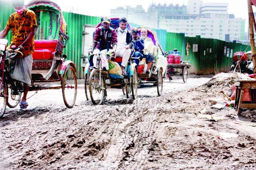Rickshaw pullers carrying passengers on a muddy road in the capital's Tejgaon area on Saturday as Friday's rain in the city made many roads dilapidated due to ongoing development works.