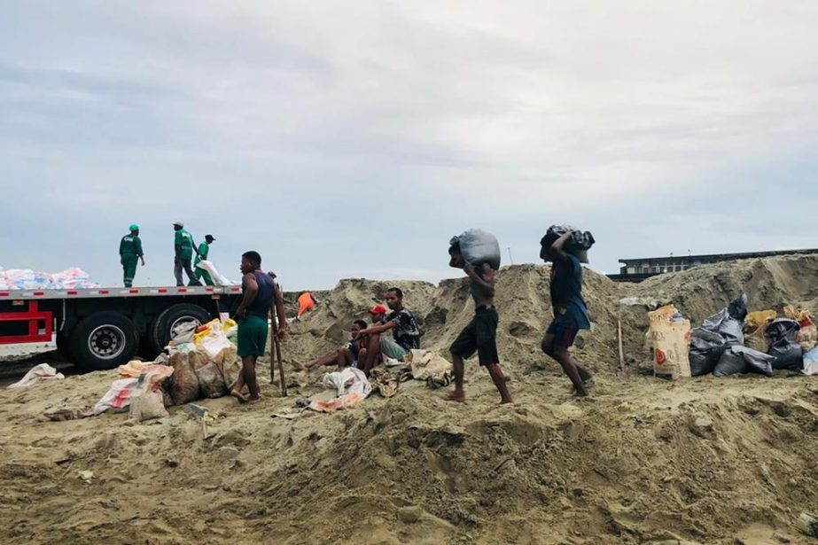 People make their way home during bad weather in Tamatave, Madagascar, Saturday, Feb. 5, 2022. Weather officials forecast that the full force of Cyclone Batsirai is to hit Madagascar Saturday evening.