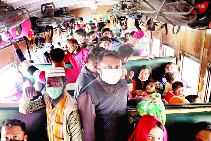 Passengers travel a train keep standing beyond sitting capacity flouting health norms as it seems to be noting prevails in the country like coronavirus. This photo was taken from Kamalapur on Wednesday.