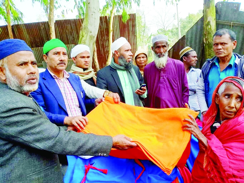 DEWANGANJ(Jamalpur): Senior journalist Khademul Islam distributes blankets among the poor people at Farazipara Village in Dewanganj Upazila organised by Fulkoli Foundation of America on Friday.
