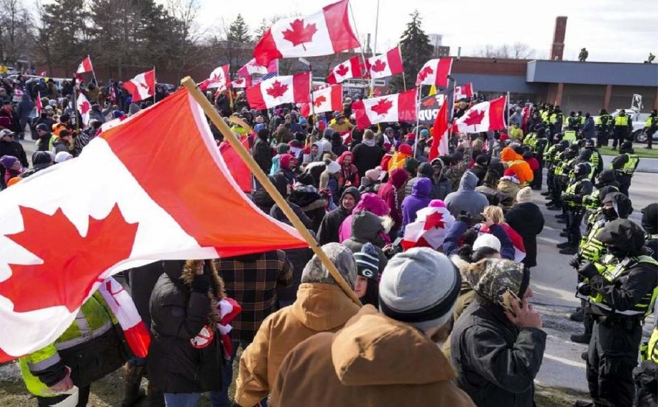 olice officers hold a line as protesters against COVID-19 restrictions march in Windsor, Ont., Saturday, Feb. 12, 2022.