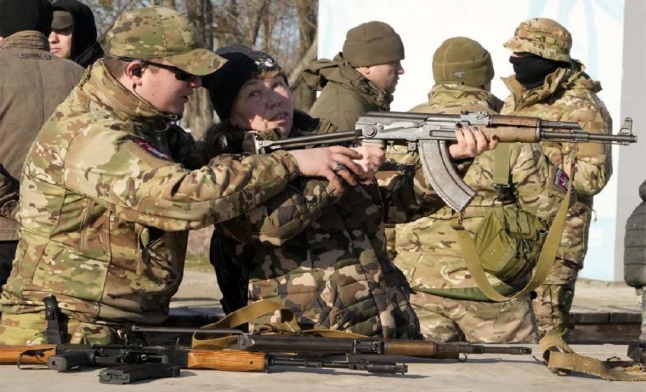 An instructor shows a woman how to use a Kalashnikov assault rifle, as members of a Ukrainian far-right group train, in Kyiv, Ukraine, Sunday, Feb. 13, 2022.