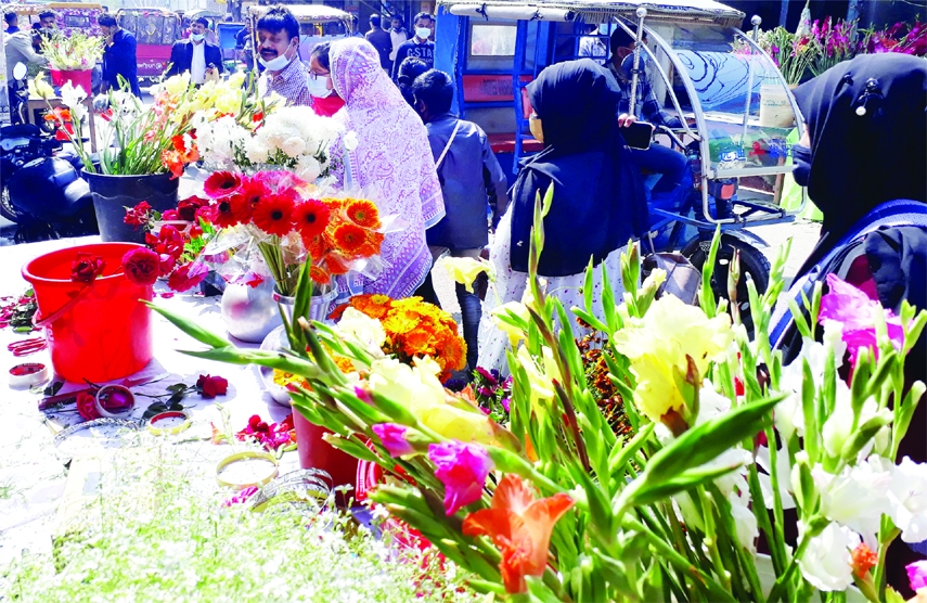 MIRZAPUR (Tangail): People gathers at road side flower shops beside old bus stand in Mirzapur Upazila on the occasion of the Pahela Falgun and Valentine's Day on Monday.