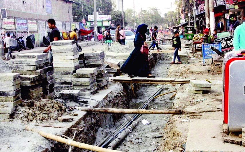 Pedestrians move through a derelict street at Tejgaon Industrial area on Wednesday which has been facing digging under G to G project. As a result, the sufferings of the city dwellers know no bounds.