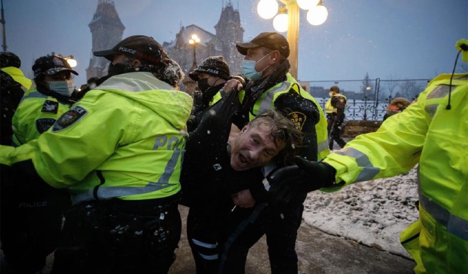 man is arrested by police as protesters and supporters gather as a protest against COVID-19 measures that has grown into a broader anti-government protest continues to occupy downtown Ottawa, Ontario, on Thursday, Feb. 17, 2022.