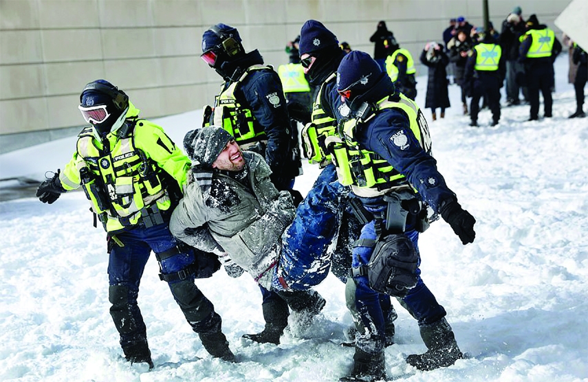 Four officers carry a handcuffed protester away from the no-go zone in Ottawa, Canada on Friday.