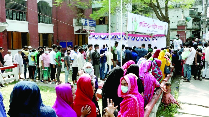 BARISHAL: People wait in long queue for taking corona shots during mass vaccination in Barishal City on Saturday.