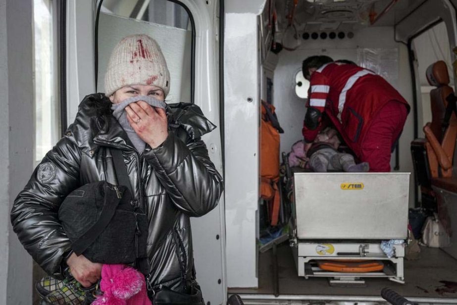 A woman reacts as paramedics perform CPR on a girl who was injured during shelling, at city hospital of Mariupol, eastern Ukraine, Sunday, Feb. 27, 2022.