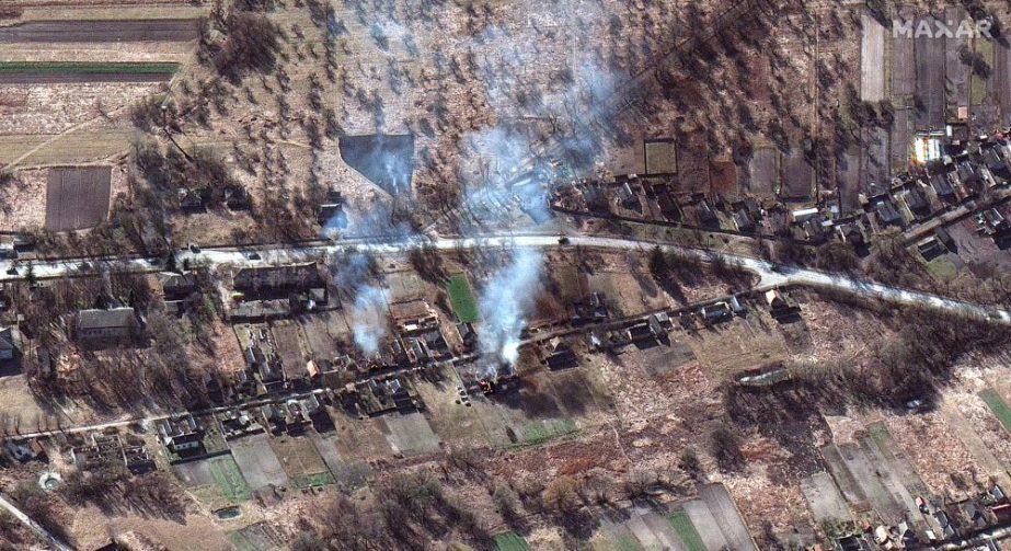 This satellite image provided by Maxar Technologies shows part of military convoy and burning homes northwest of Invankiv, Ukraine Monday, Feb. 28, 2022.