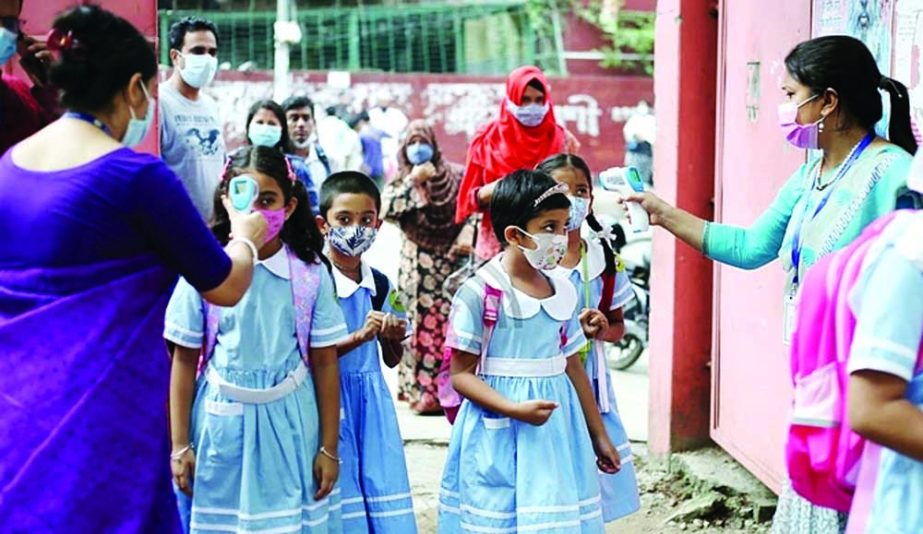 Primary children return to campus maintaining health guidelines as in-person classes resumed for early graders on Wednesday after yet another Covid-induced closure. This photo was taken from Mohammadpur Govt Primary School in the capital. NN photo