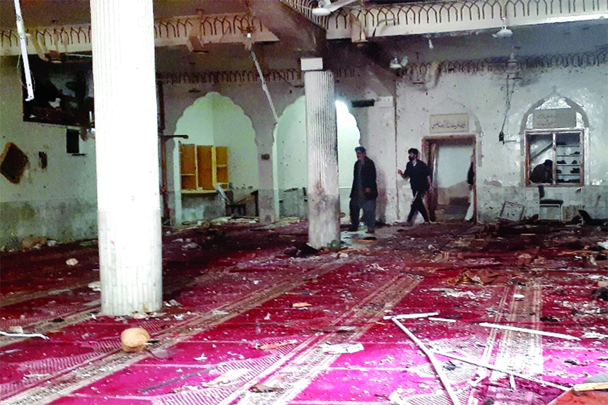 Volunteers examine the site of an explosion inside a mosque in Peshawar, Pakistan, on Friday.