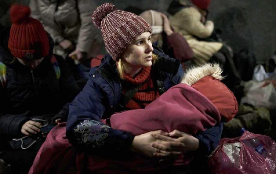 Aleksandra Tytywnnik holds her daughter as she sits inside the Lviv railway station waiting for a train to flee Ukraine, in Lviv, western Ukraine, Friday, March 4, 2022.