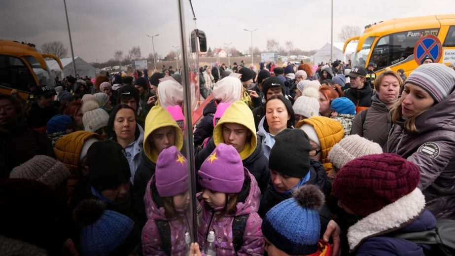 People fleeing from Ukraine queue to board on a bus at the border crossing in Medyka, Poland, Friday, March 4, 2022.