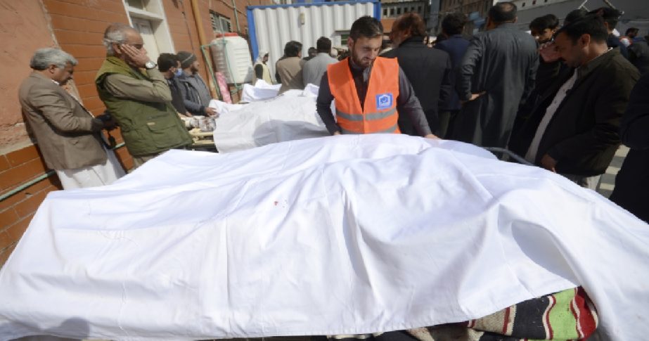 People gather around the bodies of victims in a bomb explosion outside a hospital in Peshawar, Pakistan, Friday, March 4, 2022.