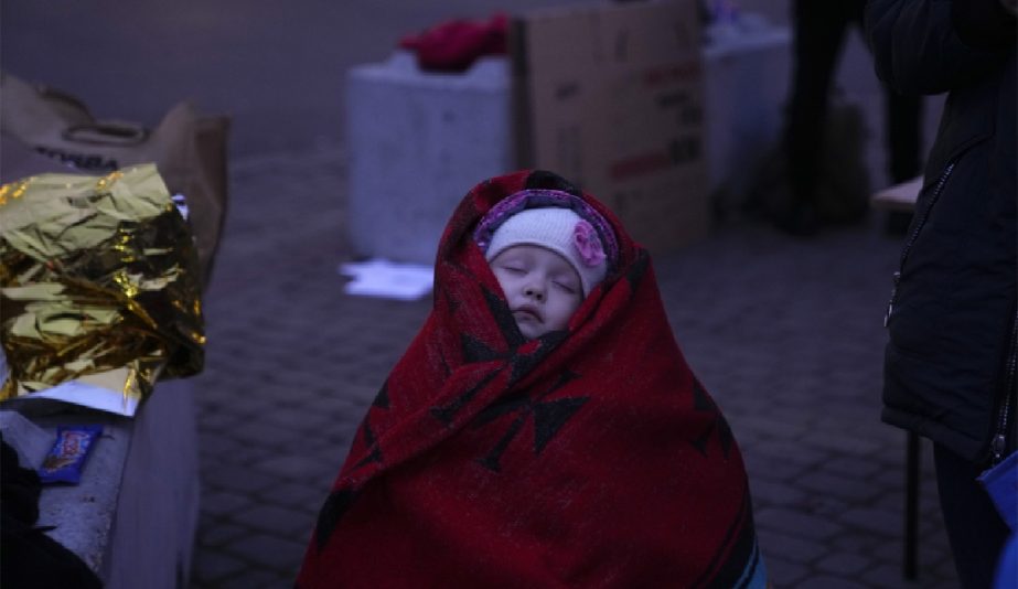 Three year old Anna is covered in a blanket as she sleeps after fleeing from the Ukraine with her brother and mother at the border crossing in Medyka, Poland, Saturday, March 5, 2022.