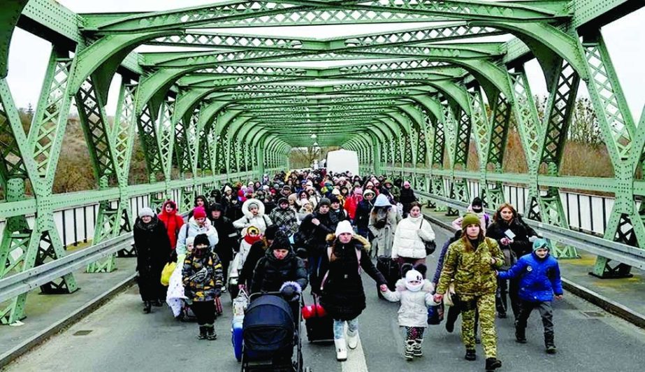 Ukrainian refugees walk a bridge at the buffer zone with the border with Poland in the border crossing of Zosin-Ustyluh, western Ukraine on Sunday. Agency Photo