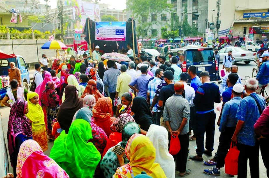 People crowd at an open market sale point of the Trading Corporation of Bangladesh to buy essential commodities at subsidised rates in the capital yesterday. NN Photo