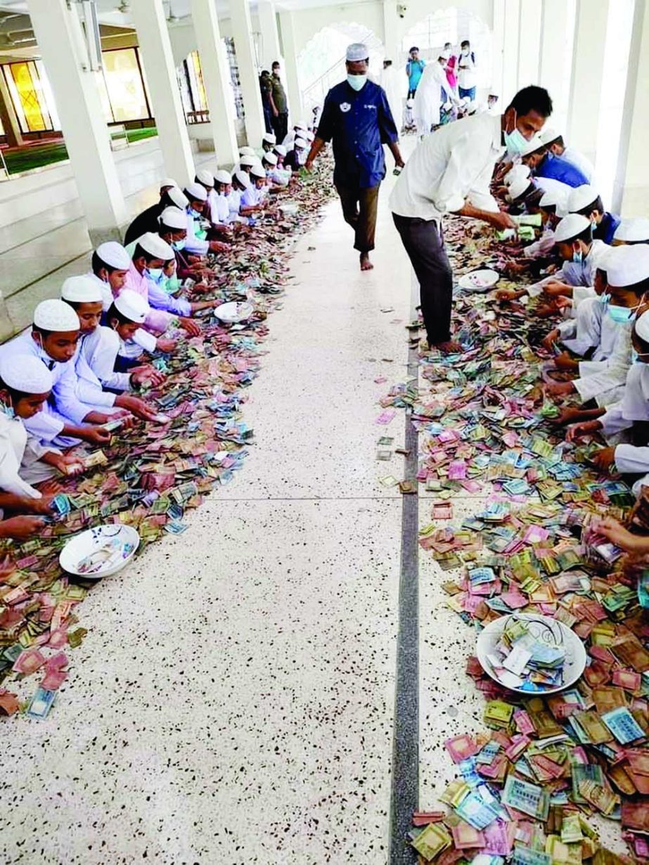 Madrassah students count the banknotes donated in charity boxes of Pagla Mosque in Kishoreganj on Sunday. NN photo