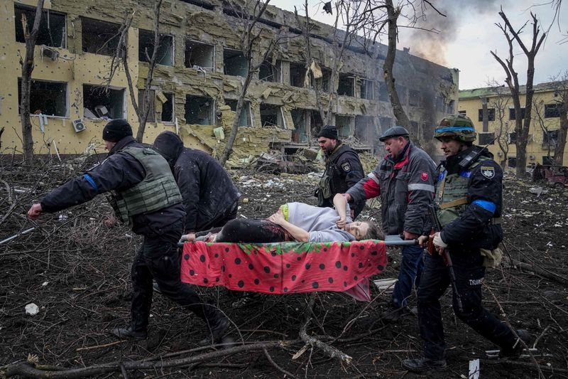Emergency employees and volunteers transport an injured pregnant woman from a maternity hospital in Mariupol, Ukraine, on March 9.