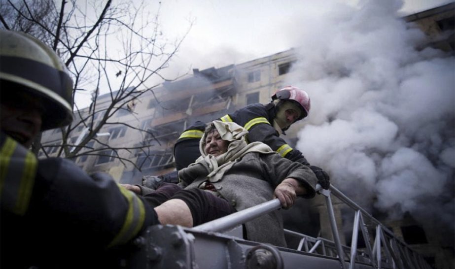 In this photo released by Ukrainian State Emergency Service press service, firefighters evacuate an elderly woman from an apartment building hit by shelling in Kyiv, Ukraine, Monday, March 14, 2022.